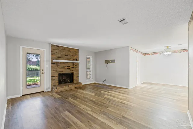 a view of an empty room with a fireplace and a window