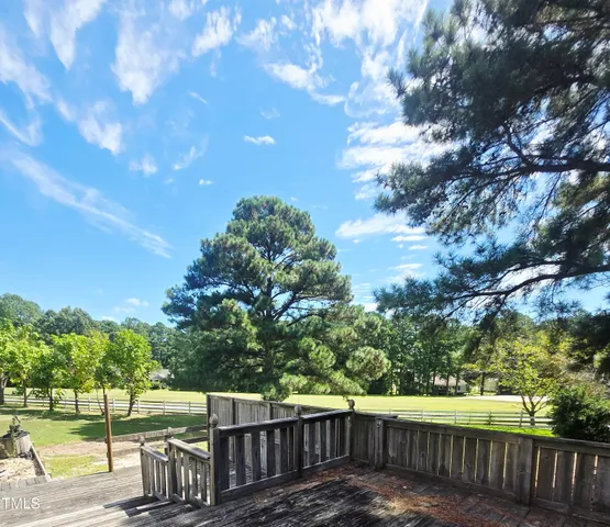 a view of a yard with wooden fence