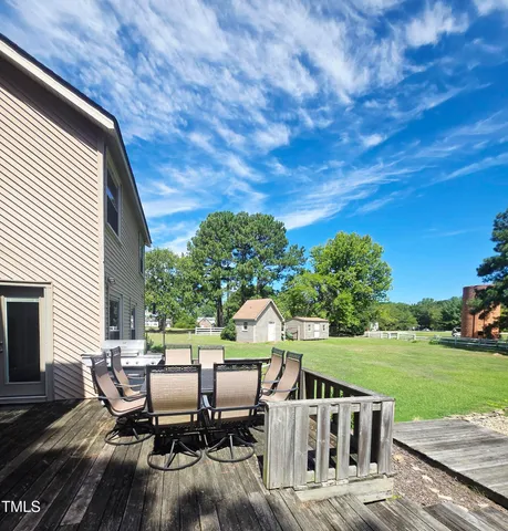 a view of backyard with outdoor seating and green space