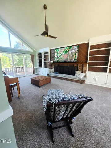 a living room with furniture a flat screen tv and a large window