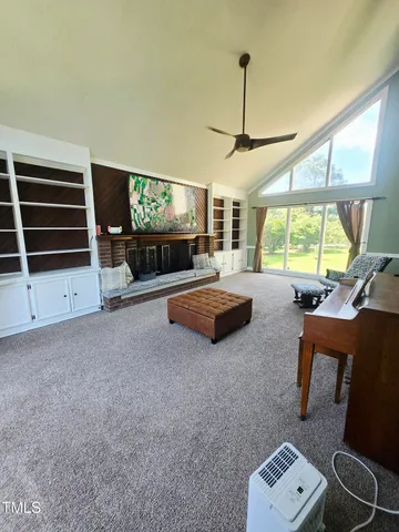 a living room with furniture a flat screen tv and a large window
