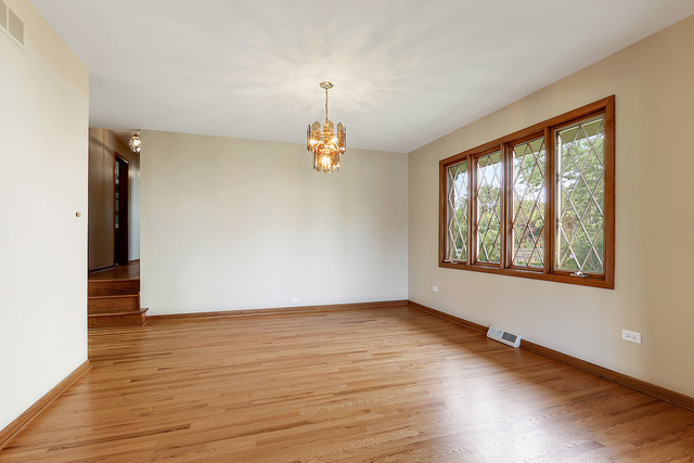 13000 Winnebago Road Palos Heights, IL 60463 - Photo 5 of 15 a view of an empty room with wooden floor and a window