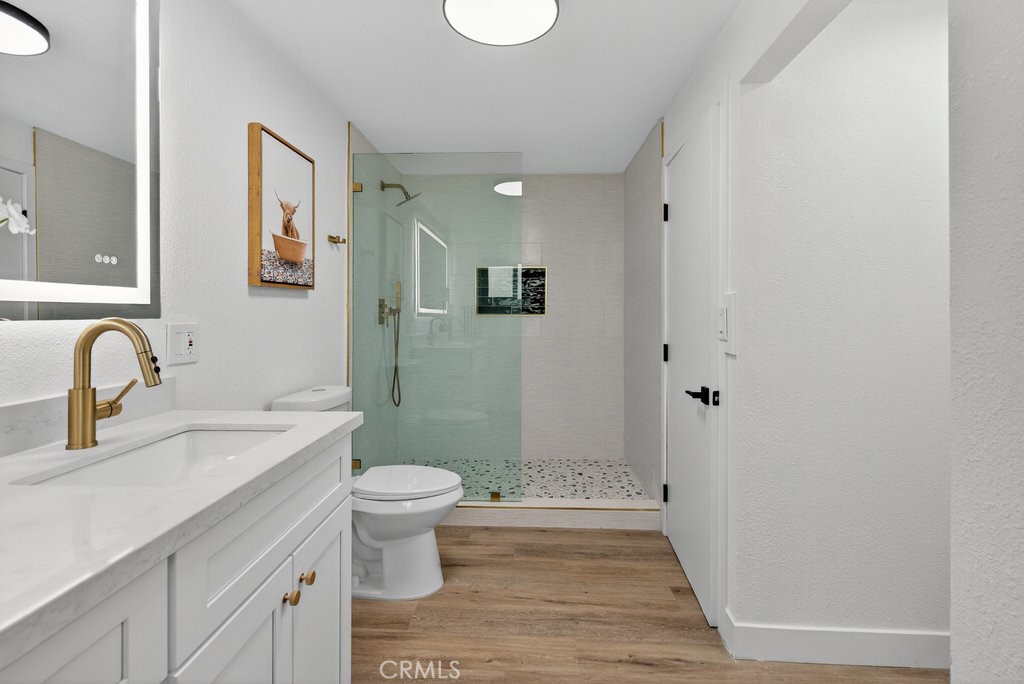a bathroom with a granite countertop sink a toilet and a mirror
