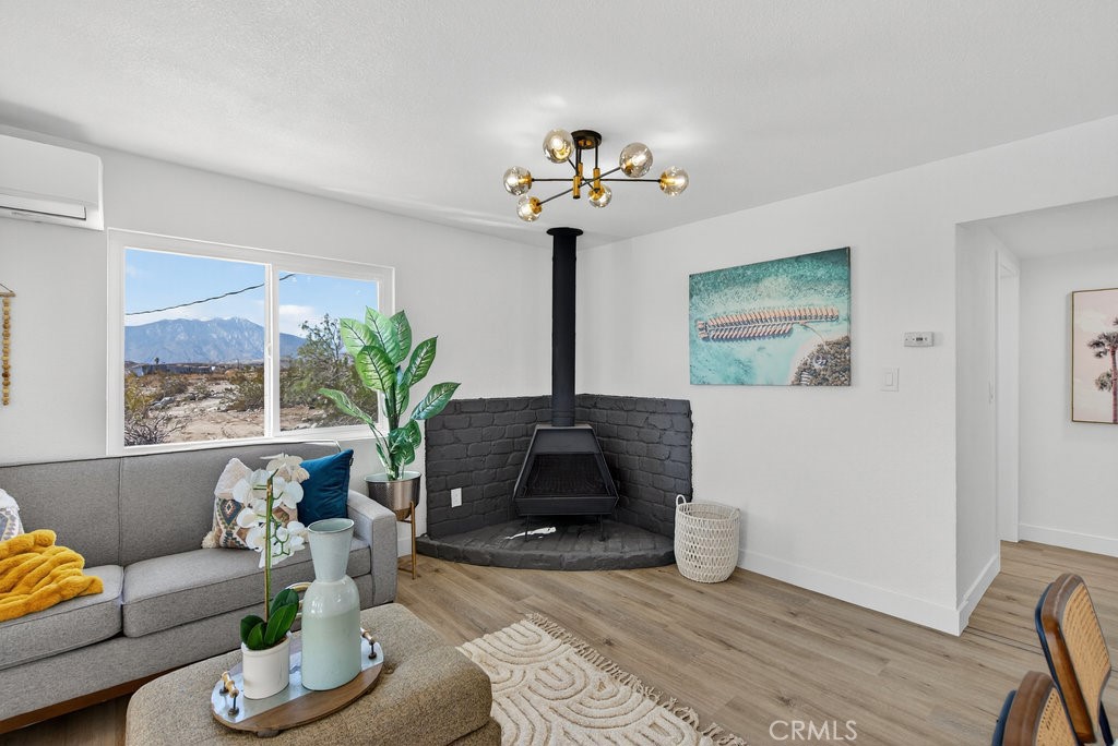 22700 Tamyran Road Desert Hot Springs, CA 92241 - Photo 11 of 65 a living room with furniture a fireplace and a potted plant
