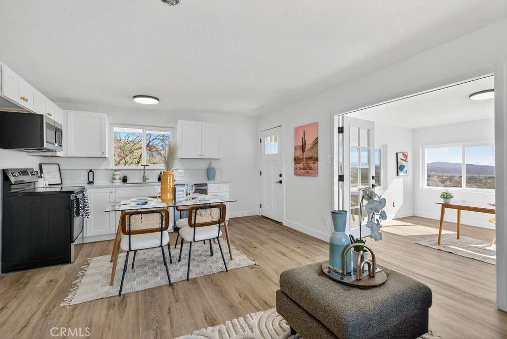 22700 Tamyran Road Desert Hot Springs, CA 92241 - Photo 12 of 65 a living room with furniture kitchen view and a wooden floor