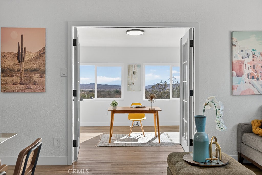 22700 Tamyran Road Desert Hot Springs, CA 92241 - Photo 19 of 65 a dining room with wooden floor and glass door