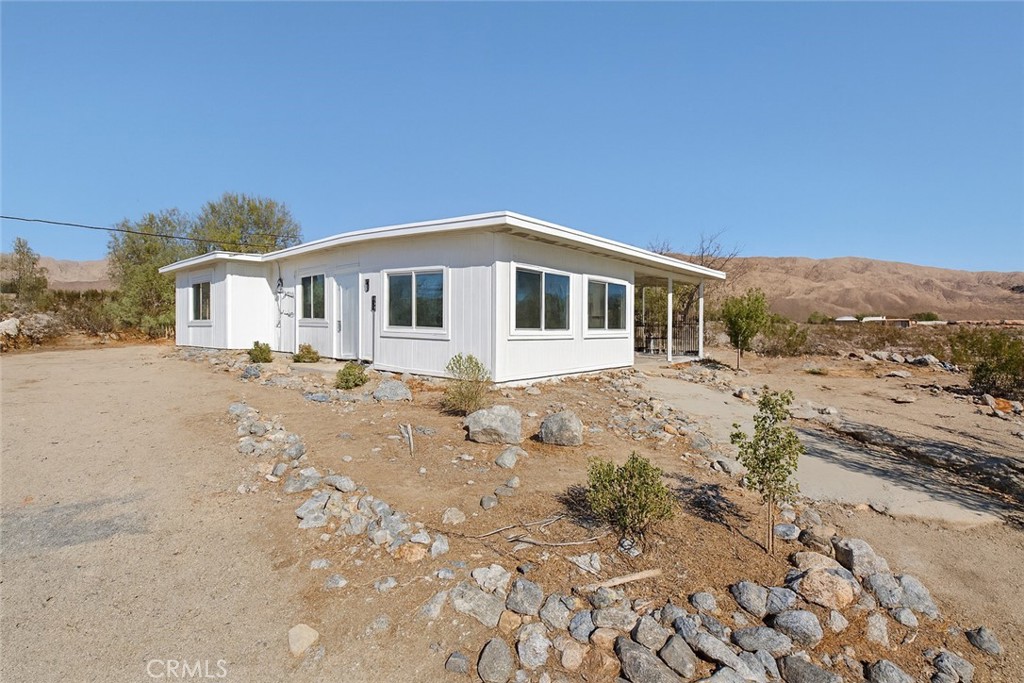22700 Tamyran Road Desert Hot Springs, CA 92241 - Photo 22 of 65 a front view of a house with a yard