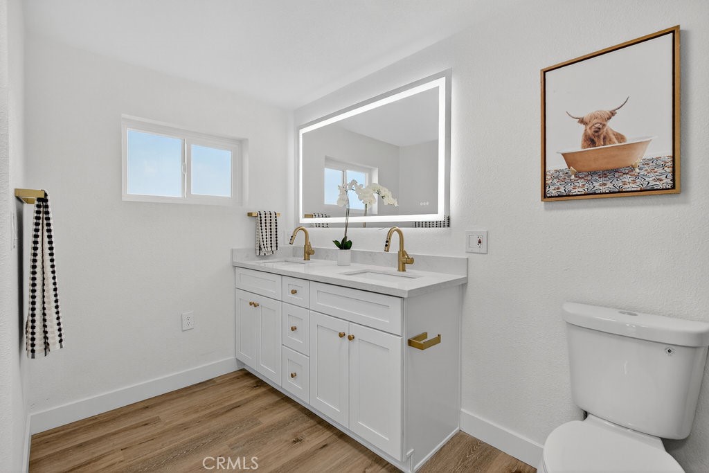 22700 Tamyran Road Desert Hot Springs, CA 92241 - Photo 29 of 65 a bathroom with a granite countertop toilet a sink and mirror