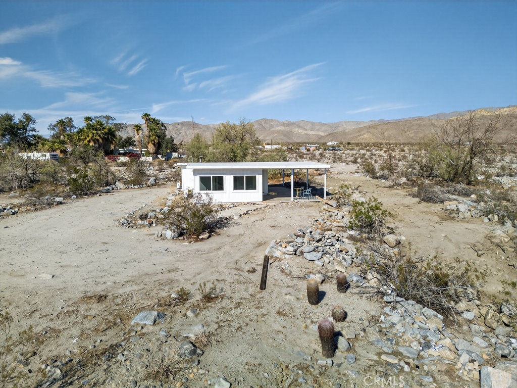 22700 Tamyran Road Desert Hot Springs, CA 92241 - Photo 50 of 65 a view of a house with a yard covered with snow in the background