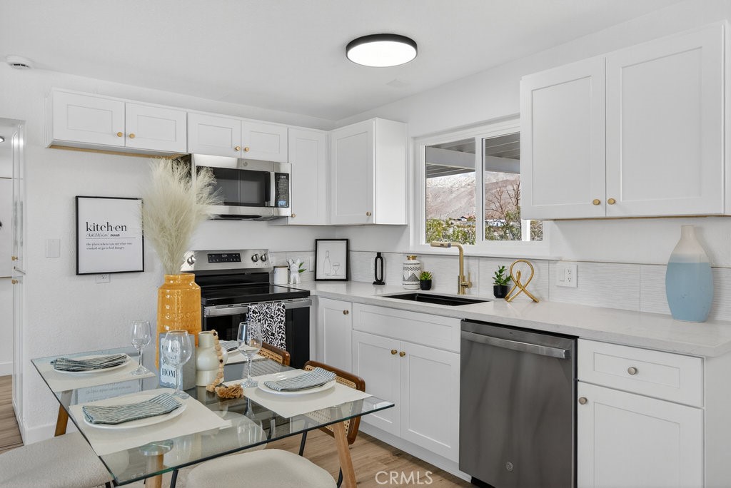 22700 Tamyran Road Desert Hot Springs, CA 92241 - Photo 5 of 65 a kitchen with a sink microwave and refrigerator