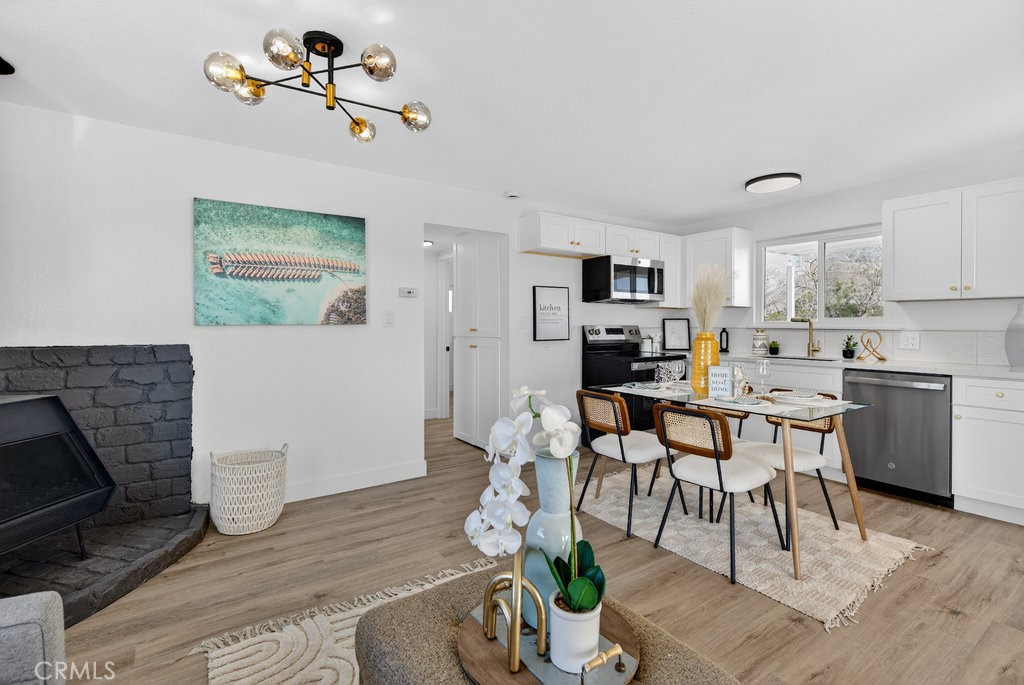 22700 Tamyran Road Desert Hot Springs, CA 92241 - Photo 7 of 65 a kitchen with a table chairs refrigerator and a wooden floor