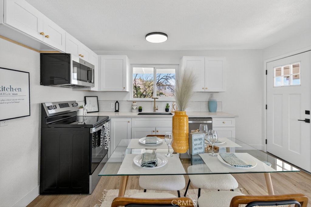 22700 Tamyran Road Desert Hot Springs, CA 92241 - Photo 9 of 65 a kitchen with stainless steel appliances granite countertop a stove a sink and a microwave