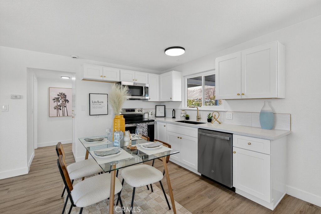 22700 Tamyran Road Desert Hot Springs, CA 92241 - Photo 10 of 65 a kitchen with stainless steel appliances kitchen island granite countertop a dining table chairs and a refrigerator