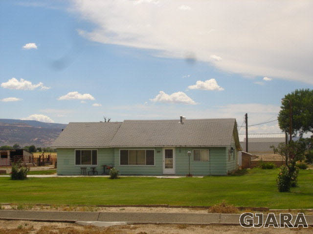 1049-19 19 1/2 Road Fruita, CO 81521 - Photo 1 of 9 a front view of a house with a garden