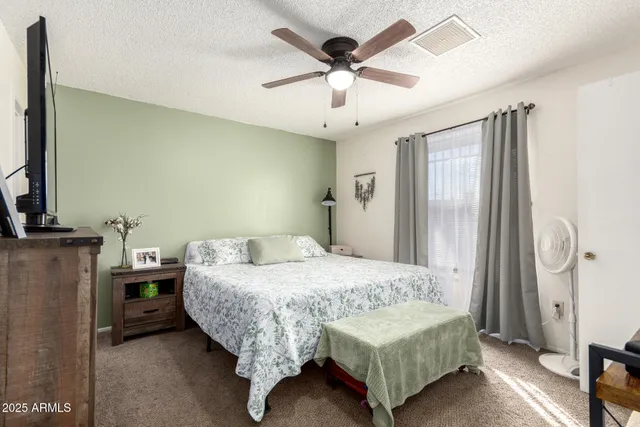 a bedroom with a bed chandelier and a window