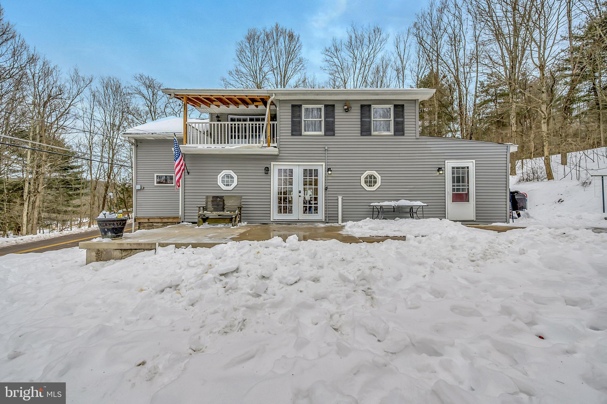 a front view of a house with a yard covered in snow