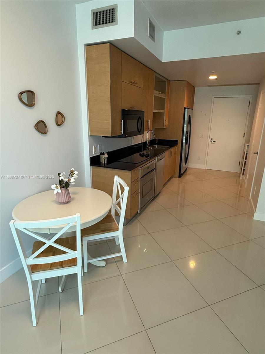 60 Southwest 13th Street, Unit 1418 Miami, FL 33130 - Photo 2 of 9 a dining room with furniture and a flat screen tv