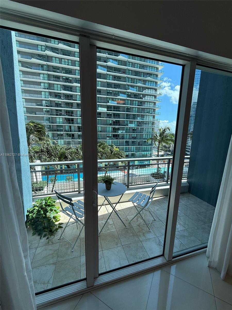 60 Southwest 13th Street, Unit 1418 Miami, FL 33130 - Photo 4 of 9 a view of a balcony with floor to ceiling window next to a yard