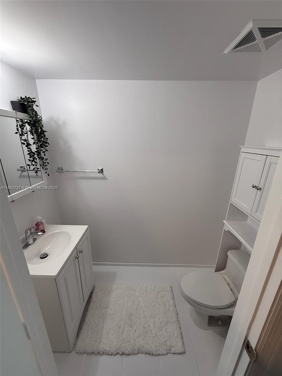 60 Southwest 13th Street, Unit 1418 Miami, FL 33130 - Photo 7 of 9 a bathroom with a sink a toilet and shower