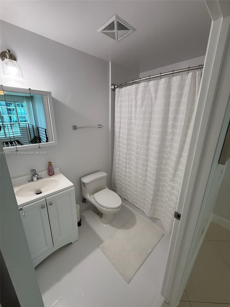 60 Southwest 13th Street, Unit 1418 Miami, FL 33130 - Photo 8 of 9 a bathroom with a sink a toilet and shower