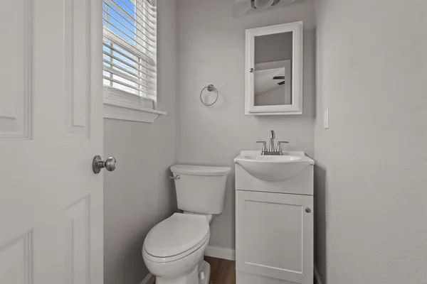 a bathroom with a toilet a sink and mirror