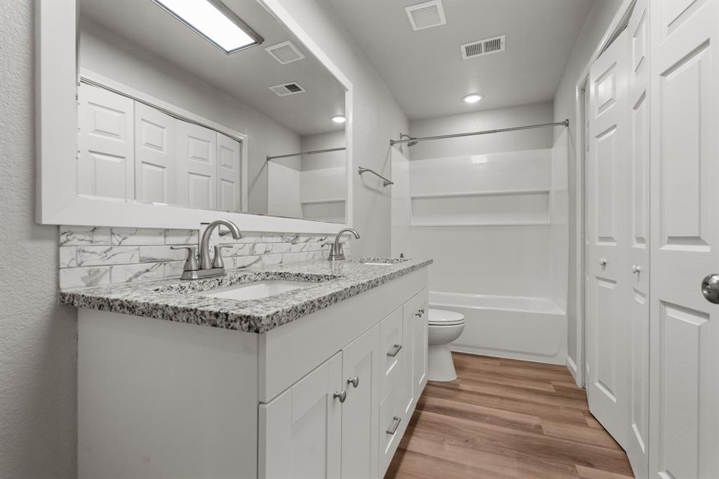 1070 East Reno Road Azle, TX 76020 - Photo 15 of 19 a bathroom with a granite countertop sink and a toilet