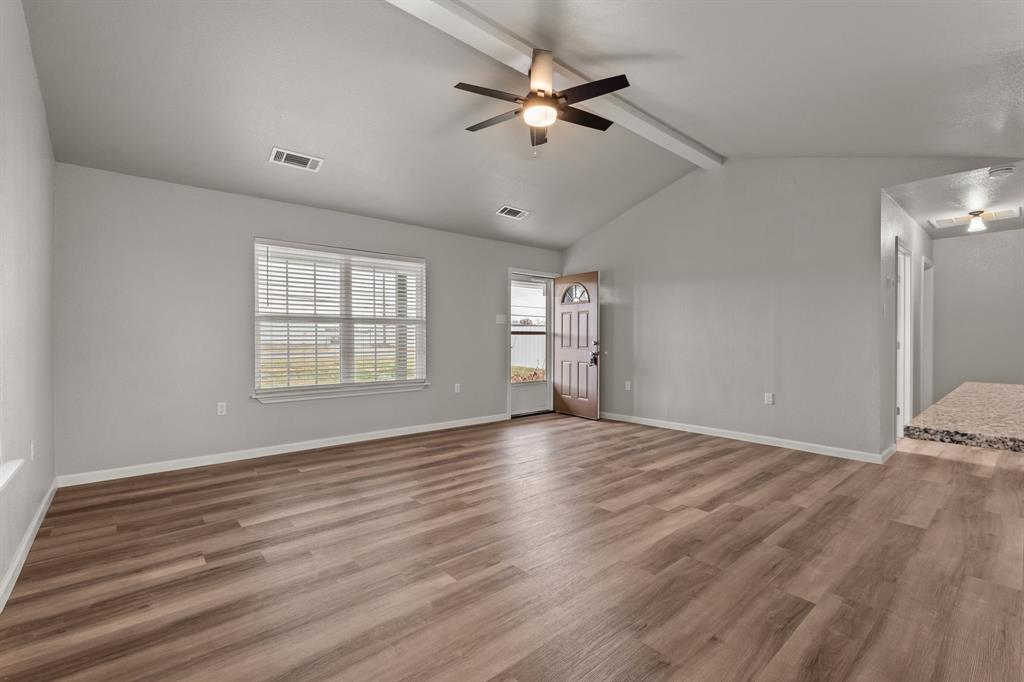 1070 East Reno Road Azle, TX 76020 - Photo 4 of 19 a view of an empty room with a window and wooden floor