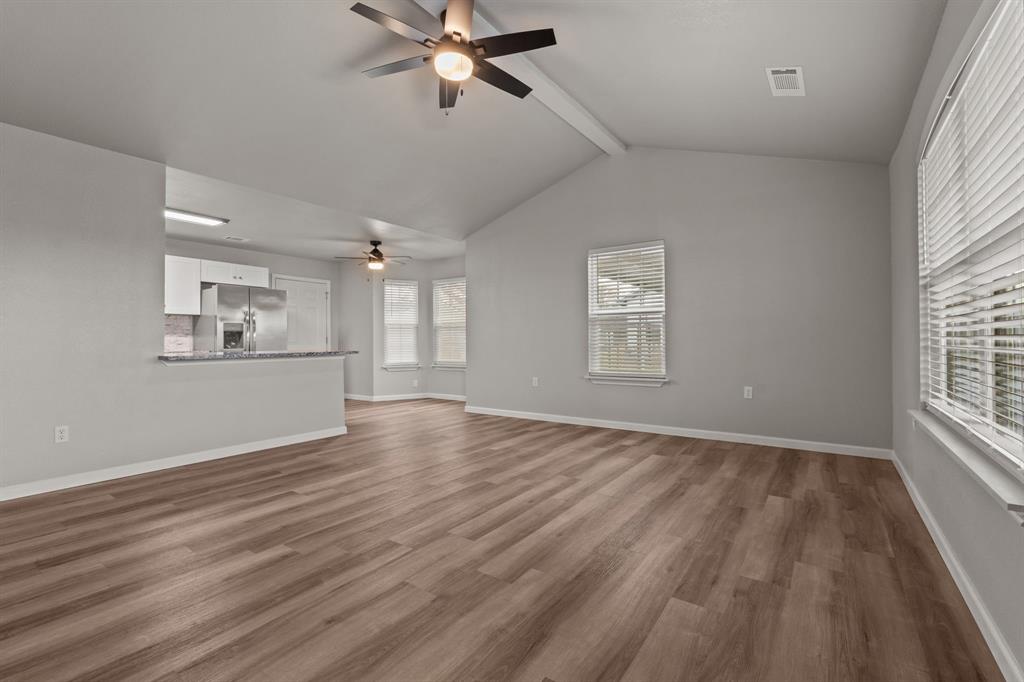 1070 East Reno Road Azle, TX 76020 - Photo 6 of 19 a view of an empty room with a window and wooden floor