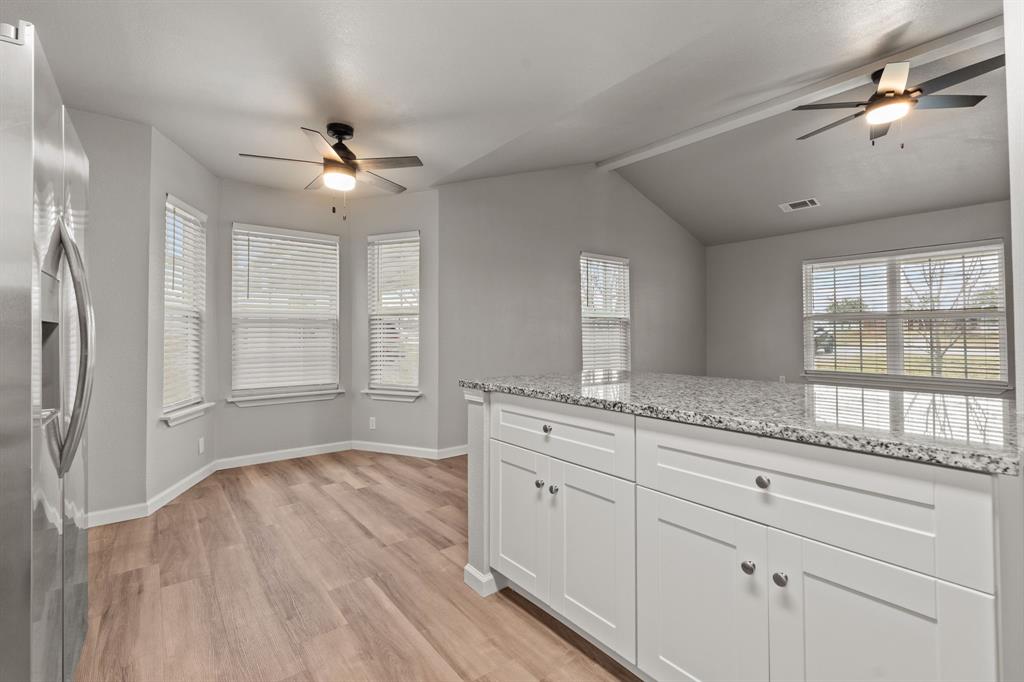 1070 East Reno Road Azle, TX 76020 - Photo 8 of 19 a open kitchen with granite countertop a stove and a refrigerator