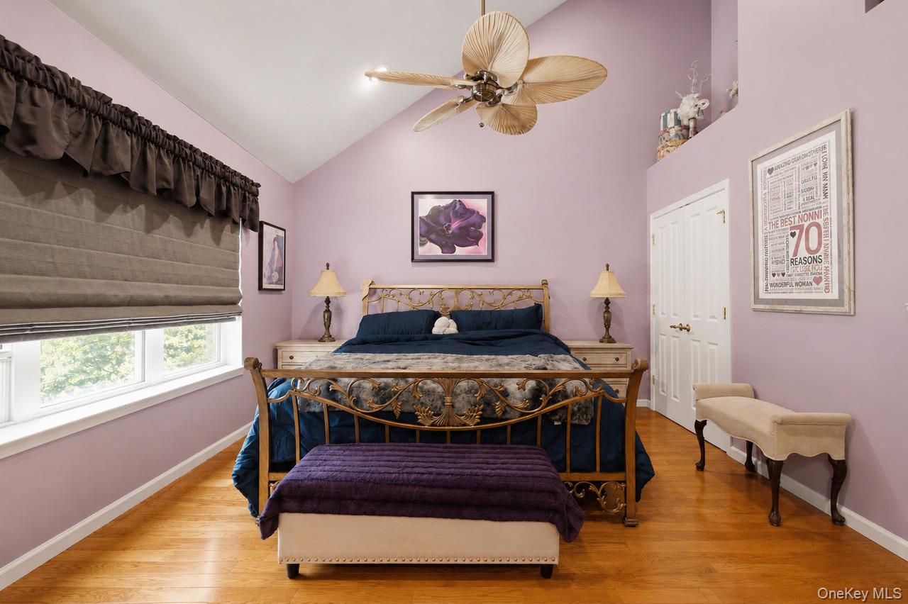64 Roma Orchard Road Peekskill, NY 10566 - Photo 19 of 40 Vaulted ceiling bedroom featuring wood-finish flooring, a ceiling fan with integrated lighting, and dual windows
