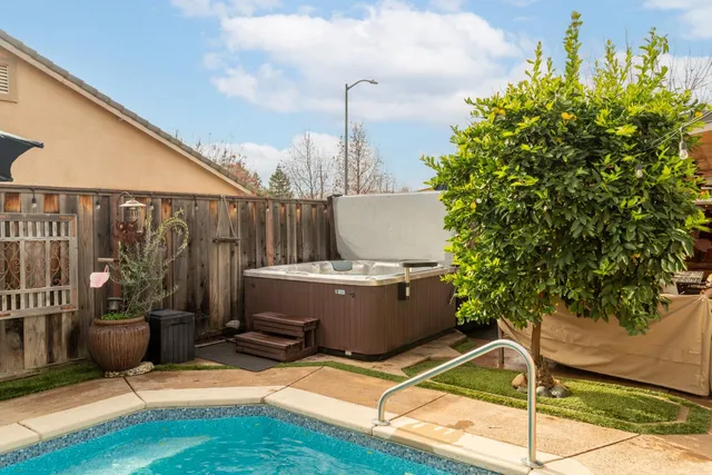 a kitchen with stainless steel appliances a dining table chairs refrigerator and sink