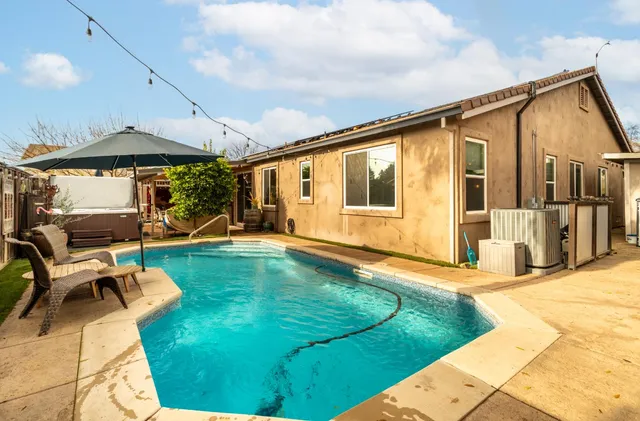 a swimming pool with patio outdoor seating and yard