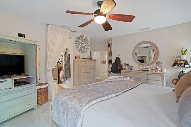 a bedroom with a bed and a flat tv screen on the dresser