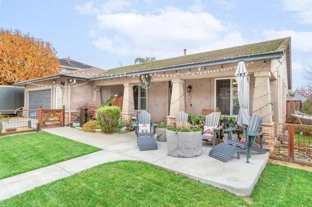 a view of a house with backyard sitting area and garden