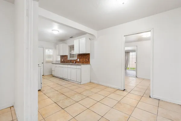 a kitchen with white cabinets and white appliances