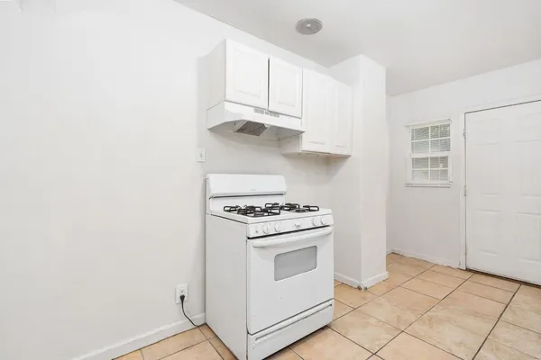 a kitchen with white cabinets and white appliances