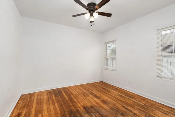 a view of empty room with wooden floor