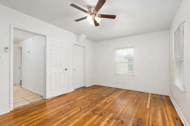 a view of a room with wooden floor and a ceiling fan