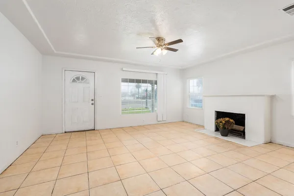 a view of an empty room with a fireplace and a window