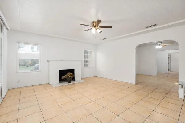 a view of an empty room with a fireplace and a window