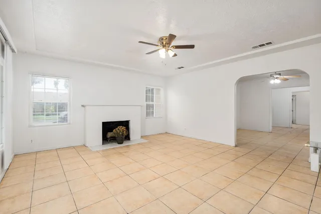 a view of an empty room with a fireplace and a window