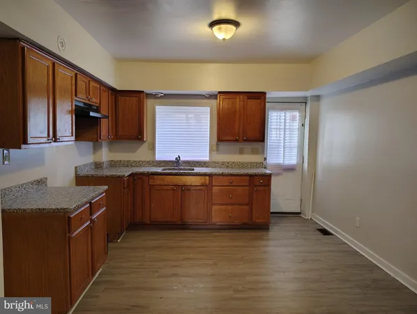 a large kitchen with granite countertop a sink and a stove top oven
