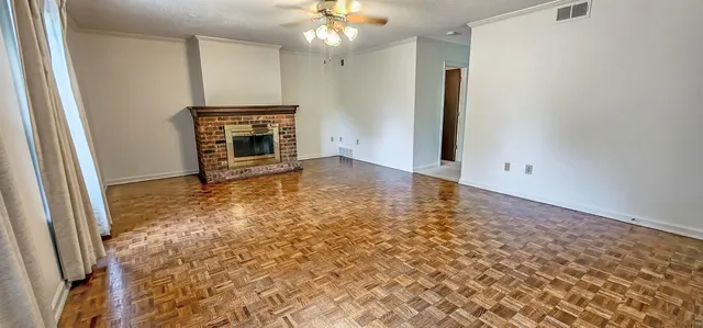 an empty room with windows and fireplace