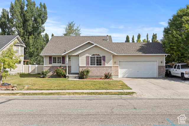 1099 Three Point Avenue Logan, UT 84321 - Photo 2 of 27 View of front of house featuring a garage, concrete driveway, brick siding, and roof with shingles