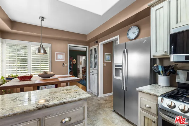 a kitchen with stainless steel appliances granite countertop a sink a stove and a refrigerator