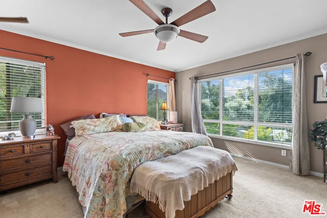 a bedroom with a bed and a large window