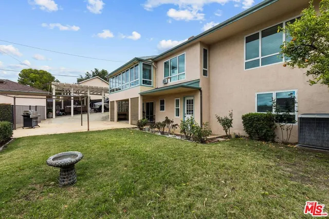 a view of an house with backyard space and balcony