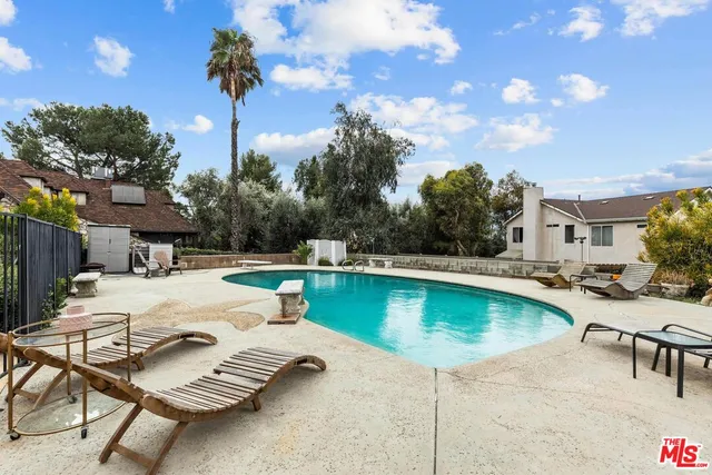 a swimming pool with outdoor seating and yard