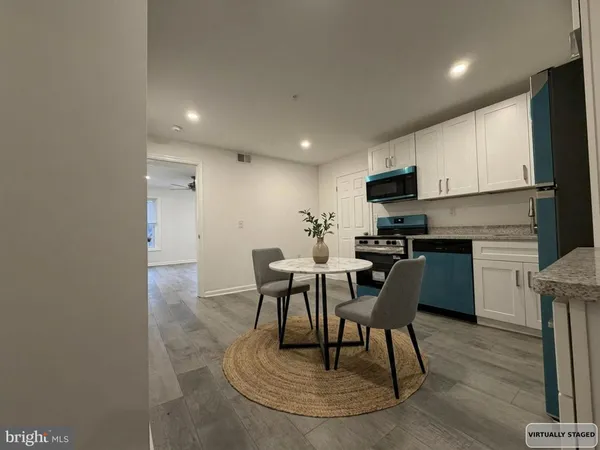 a kitchen with a dining table chairs and white cabinets