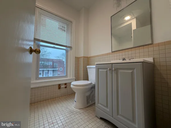 a bathroom with a toilet sink and mirror